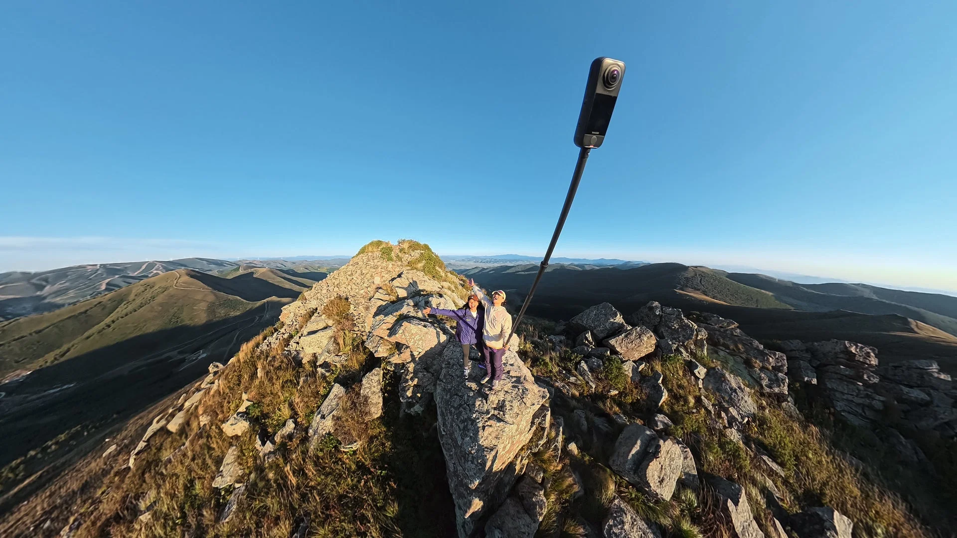 山頂でInsta360 X4 Airを使い広大な景色を撮影する人々