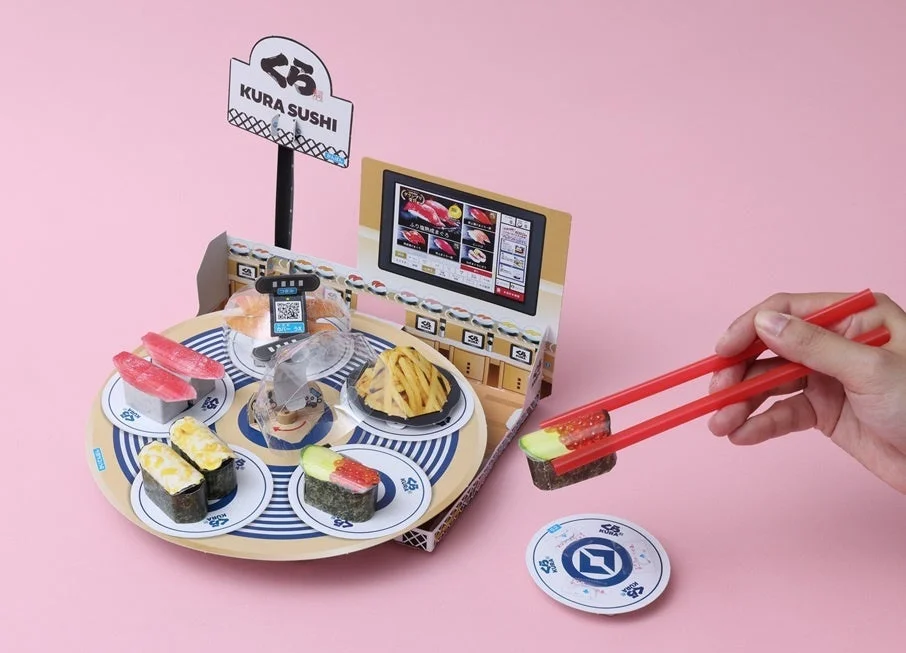 くら寿司コラボ付録「おはしで!かいてんずし つかみゲーム」で箸を使って寿司をつかむ様子