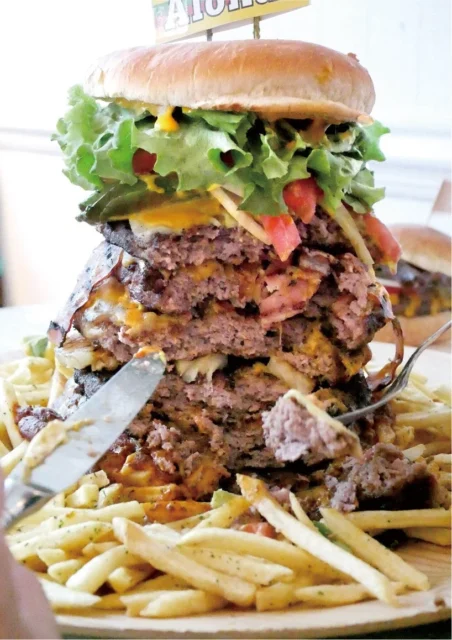 ナイフとフォークで切り分けられる「テラモンスターバーガー」。