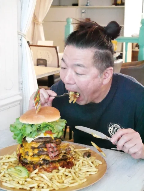 「テラモンスターバーガーチャレンジ」に挑戦する男性の様子。