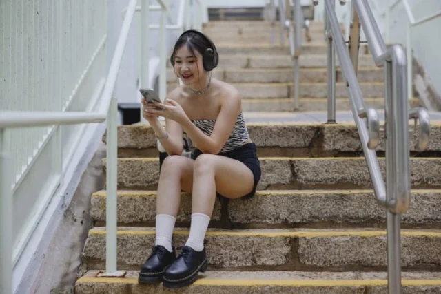 JBL Tune 730BTを装着しスマートフォンを使用する女性