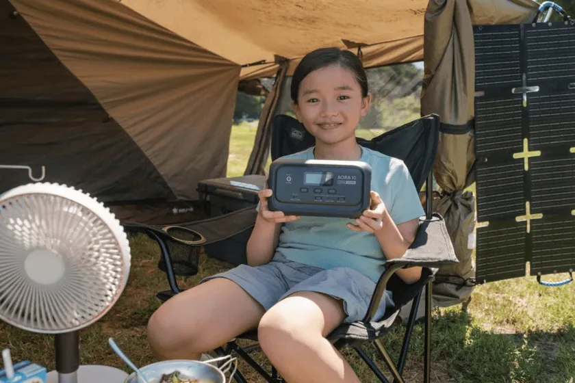 BLUETTI AORA 10をキャンプで使用する子供、持ち運びやすい軽さを表現