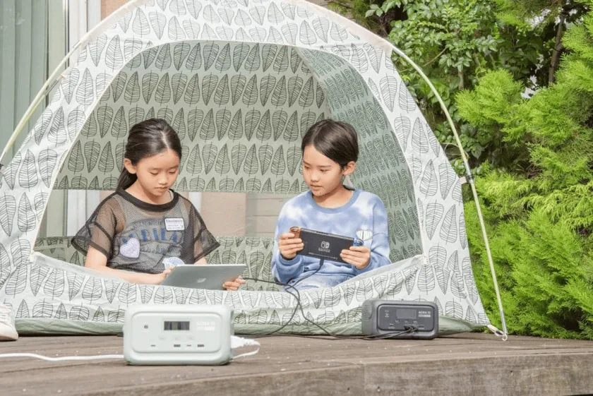 BLUETTI AORA 10を使ってテント内でタブレットとゲームをする子供たち