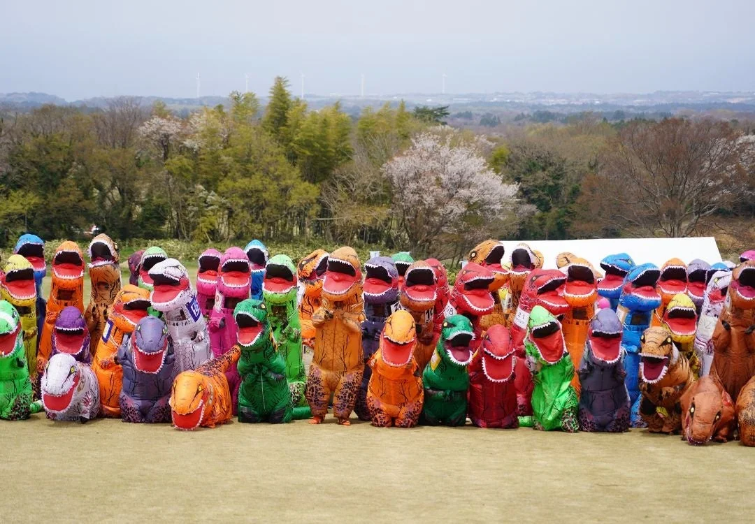 カラフルなティラノサウルスの着ぐるみを着た参加者たち
