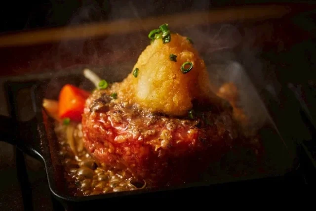 鉄板で焼かれる大根おろしトッピングのハンバーグ