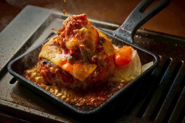 鉄板で焼かれるチーズとキムチのハンバーグ