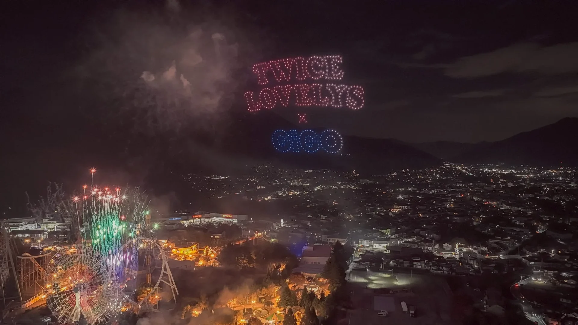 富士急ハイランド上空にTWICE LOVELYSとGiGOのロゴがドローンで描かれ、花火が打ち上がる夜景