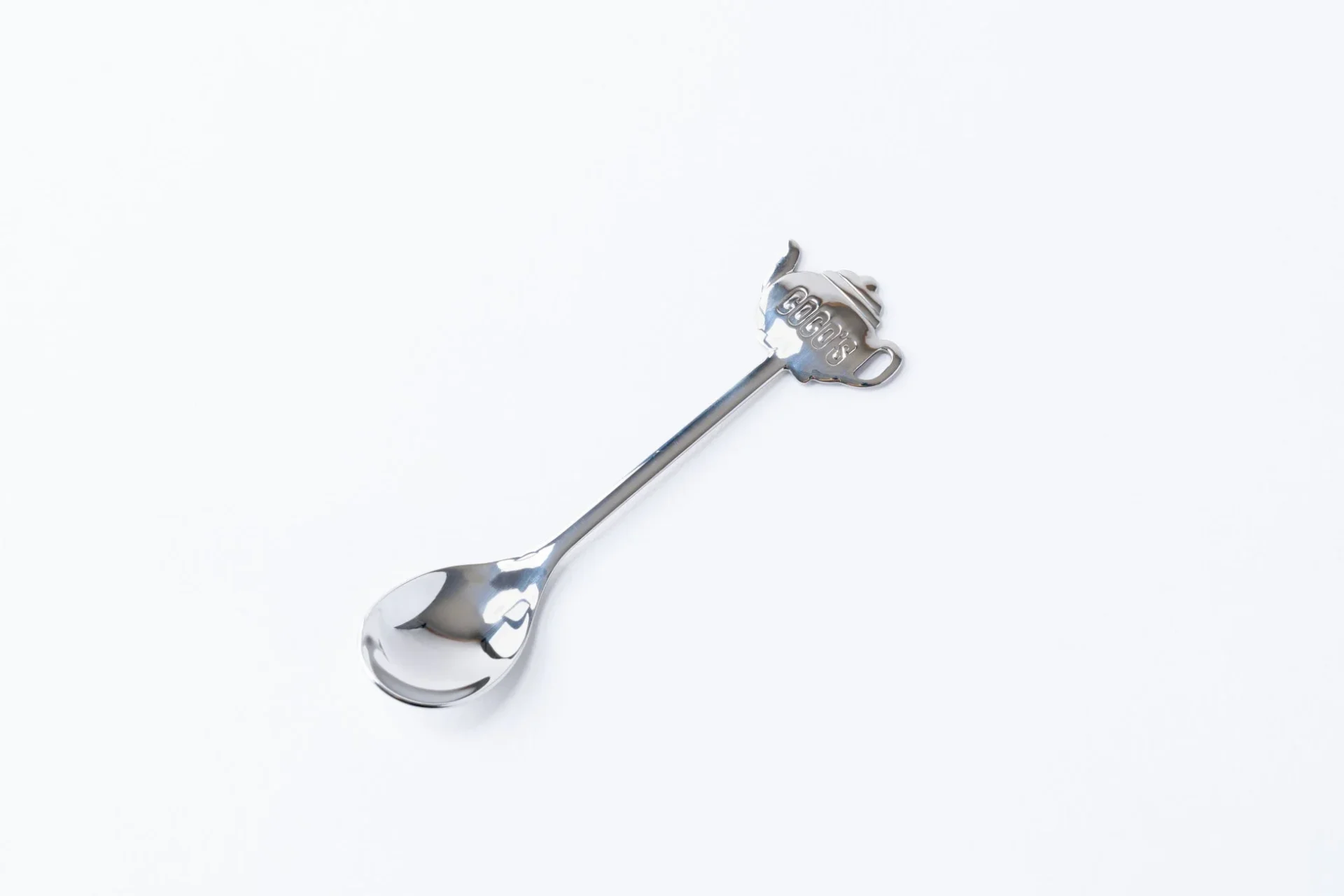 ココスのロゴがあしらわれたティーポットデザインのティースプーン