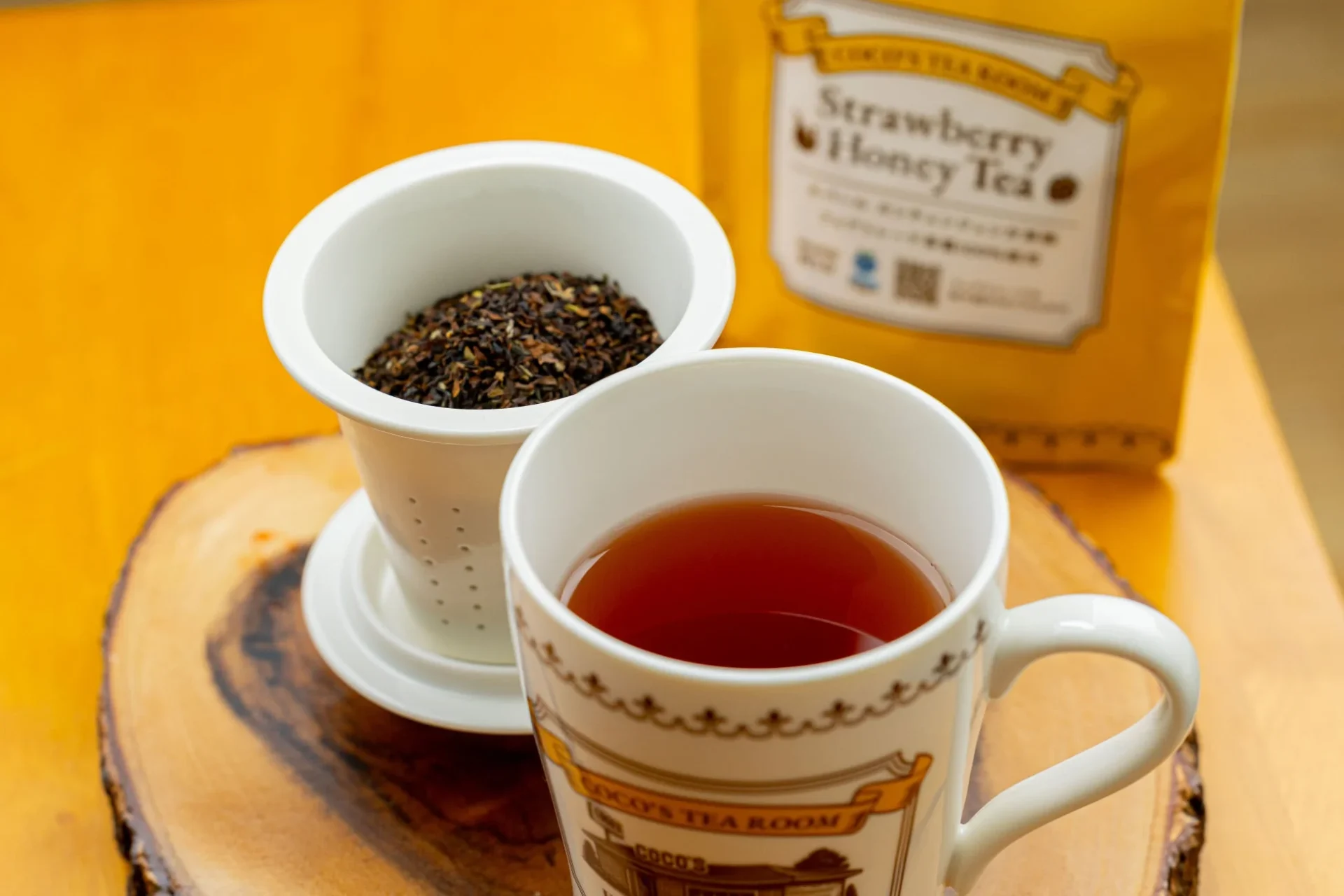 ストロベリーハニーティーを淹れたマグカップと茶葉の入った茶こし
