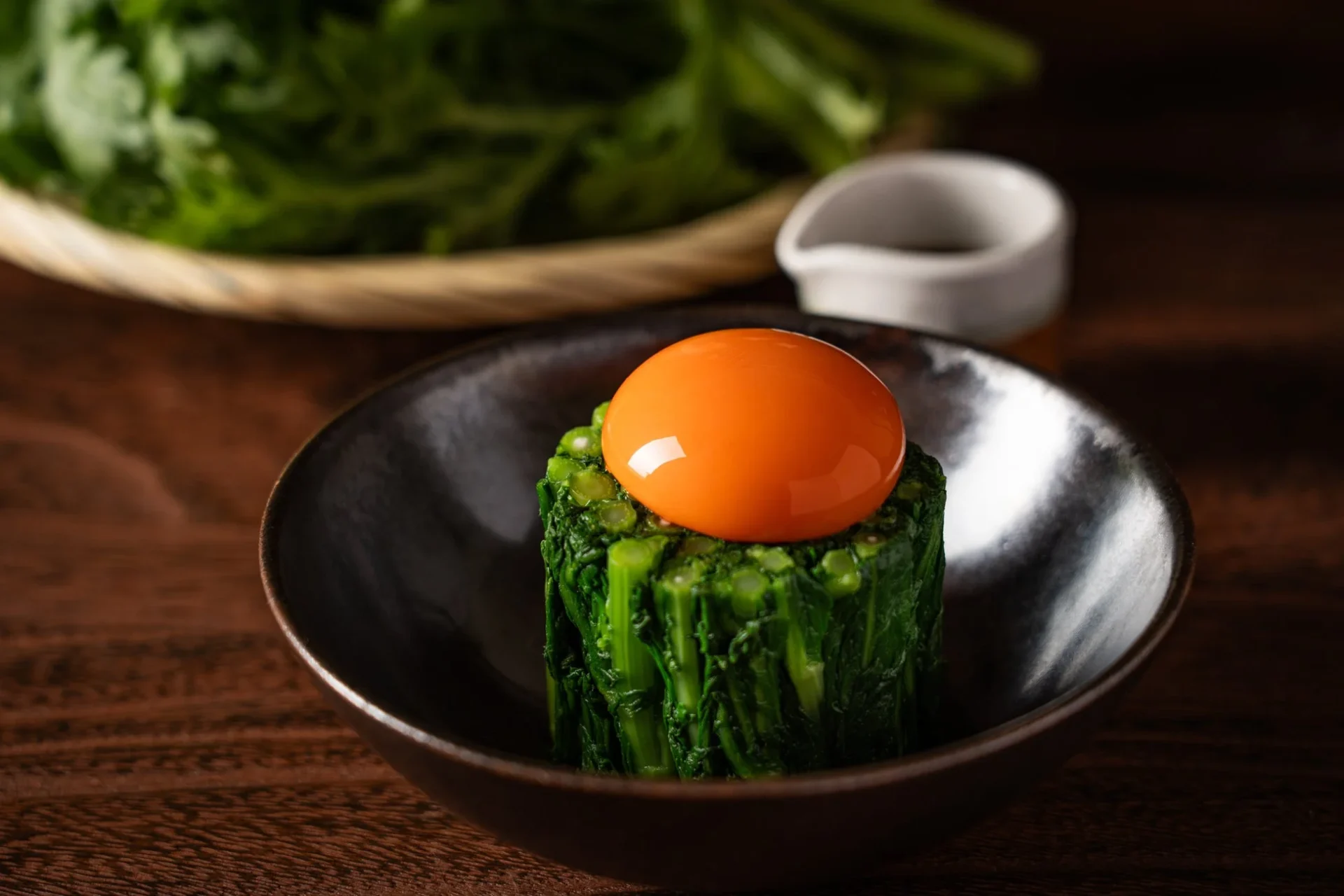 大葉春菊の釜玉。さっと湯がいた大葉春菊の上に塚だまの黄身が乗っている。