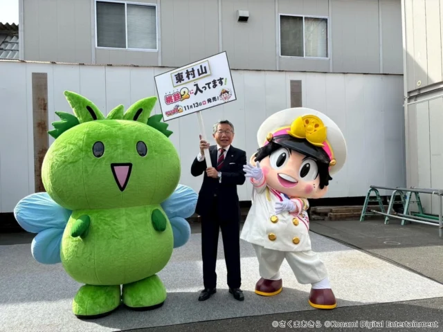 桃太郎が東村山市長と公式キャラクターひがっしーと記念撮影している様子