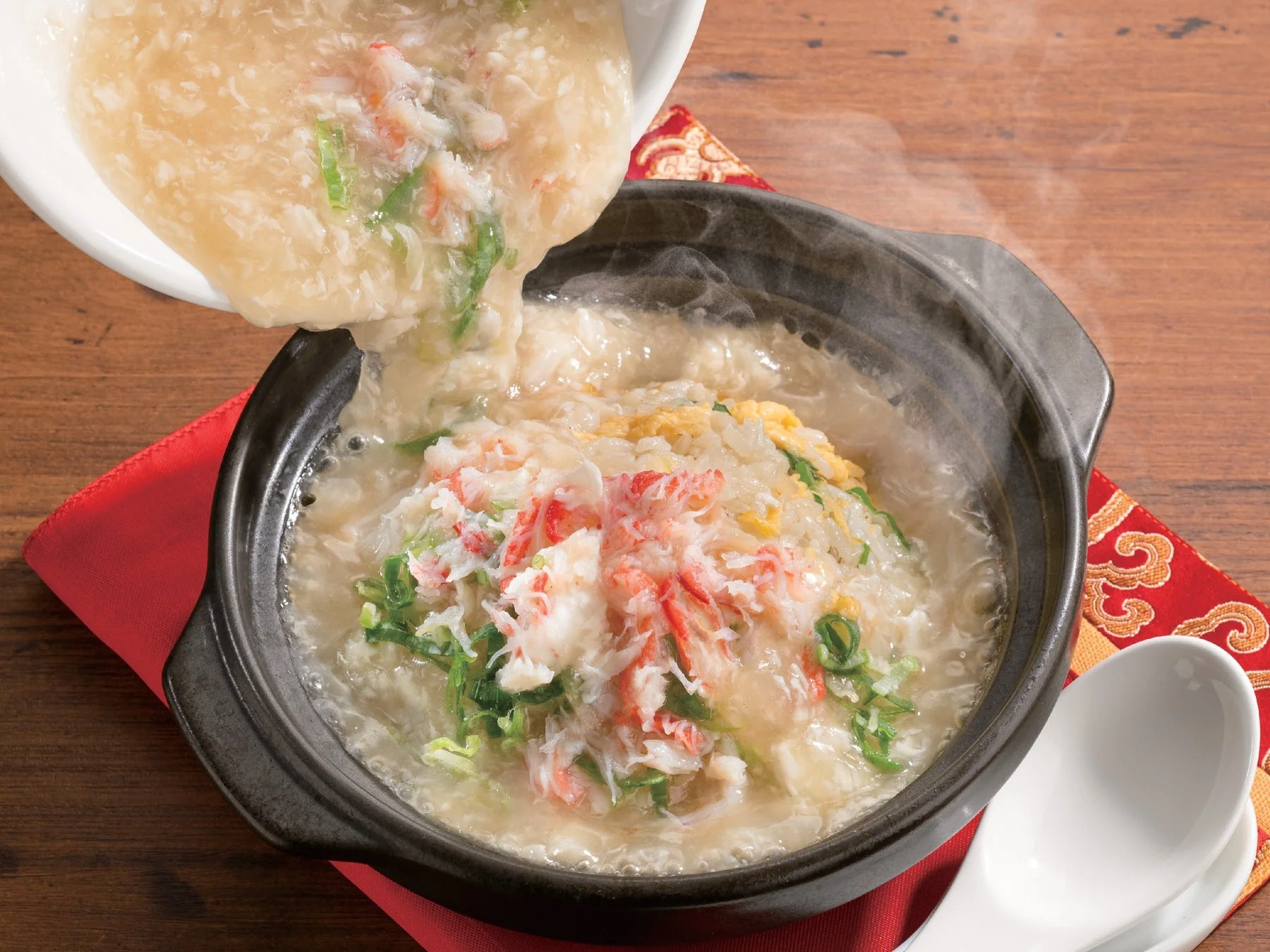 熱々の餡をかけて仕上げる本ずわい蟹あんかけ土鍋チャーハン