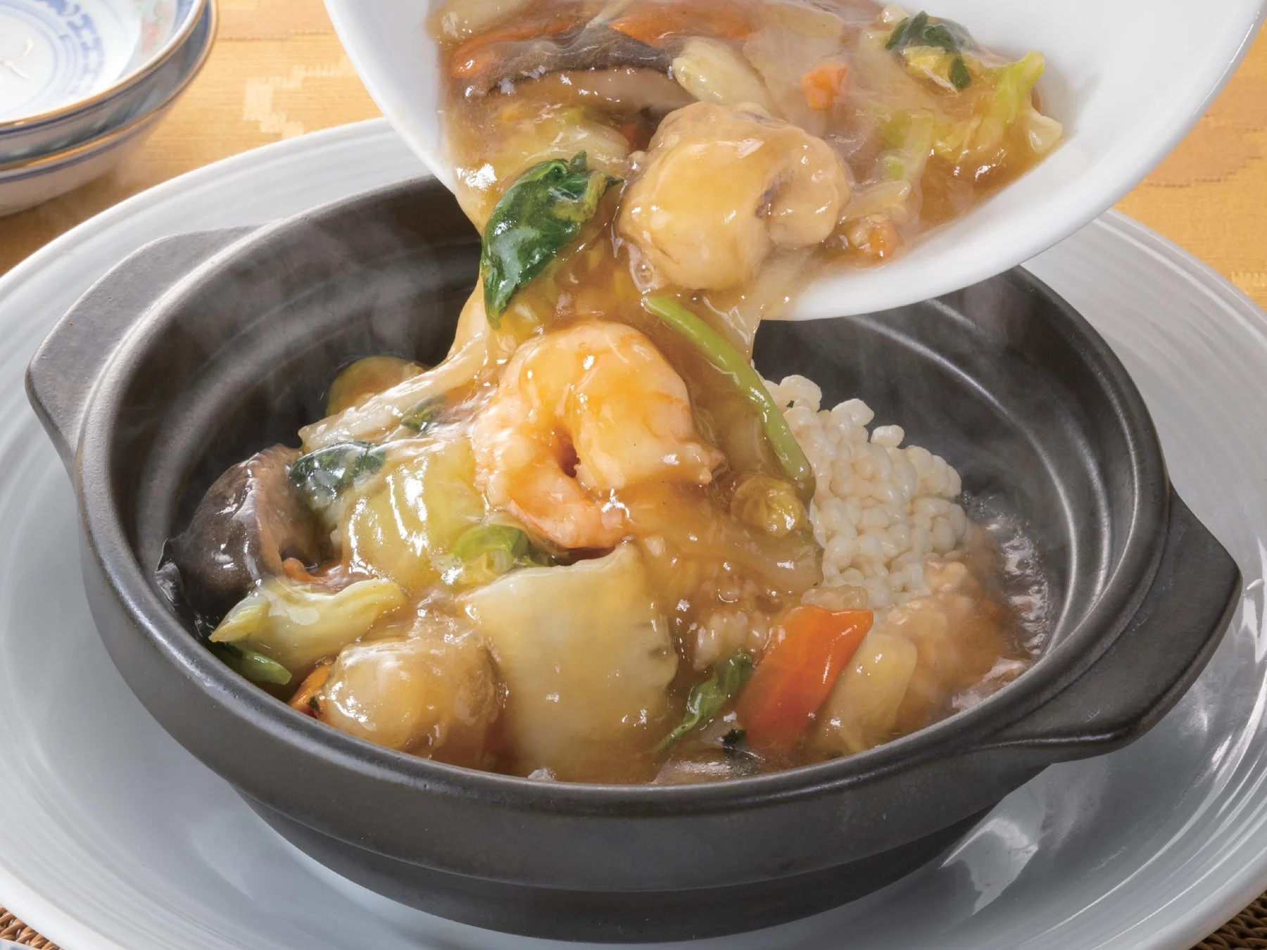 海鮮の旨味が詰まったあんかけがかかった熱々おこげ