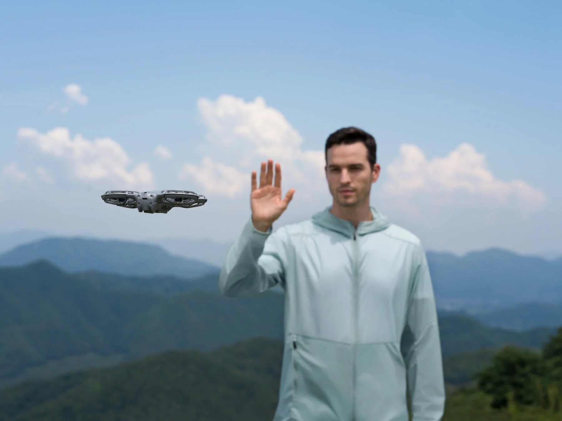 ドローンに片手でジェスチャー操作する男性
