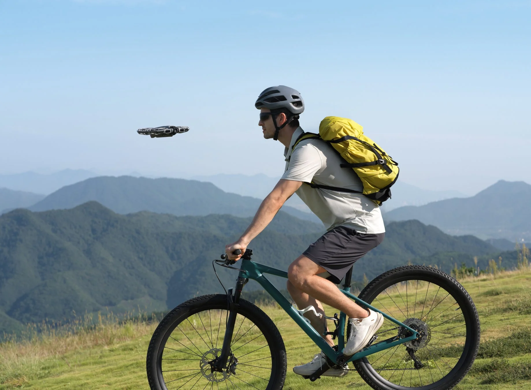 山道をサイクリングする男性を追従撮影するDJI Neo 2