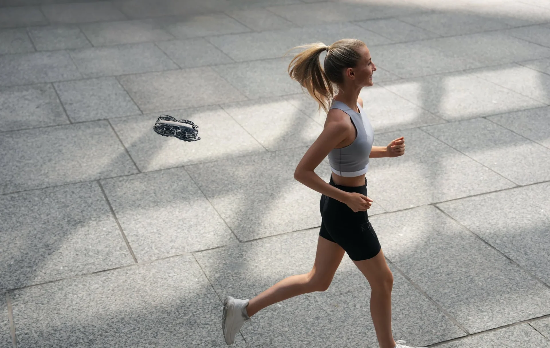 市街地をランニングする女性を追従撮影するDJI Neo 2