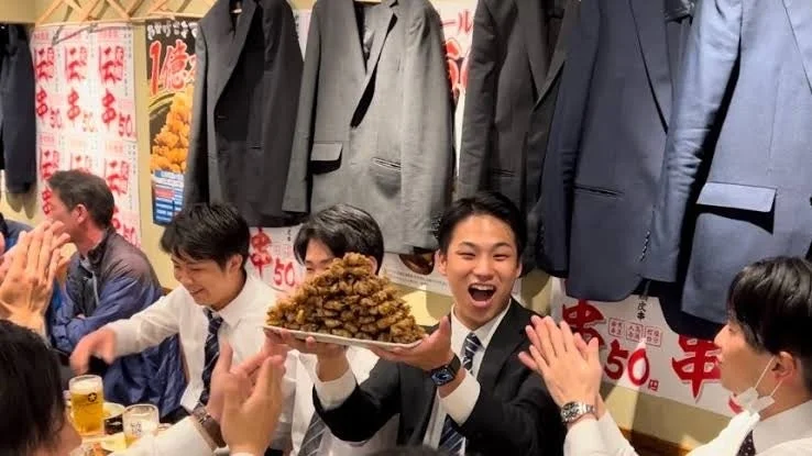 伝串ピラミッドを囲んで楽しむお客さんたち