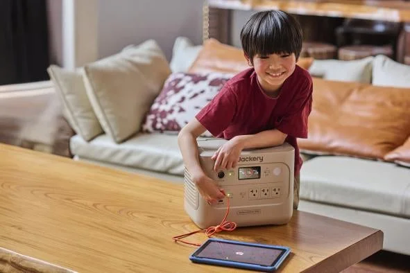 Jackeryポータブル電源1000 Newでタブレットを充電する子供