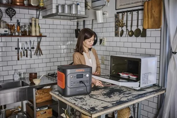 Jackeryポータブル電源2000 Newで電子レンジを使用する女性