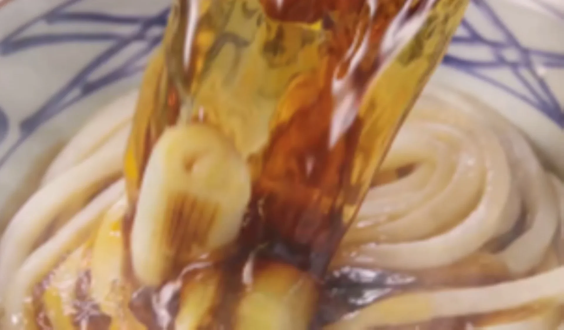 丸亀製麺の鴨ねぎうどん、打ち立てうどんに特製鴨だしを注ぎ込む様子