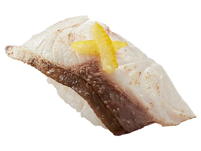 炙られた寒ぶりに柚子が添えられた国産活〆寒ぶり塩炙り柚子のせの握り寿司。