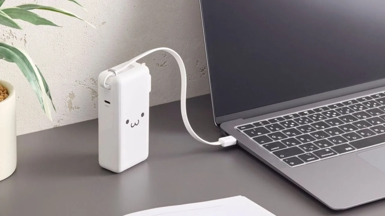 ホワイトモデルのエレコム一体型モバイルバッテリーでノートPCを充電する様子