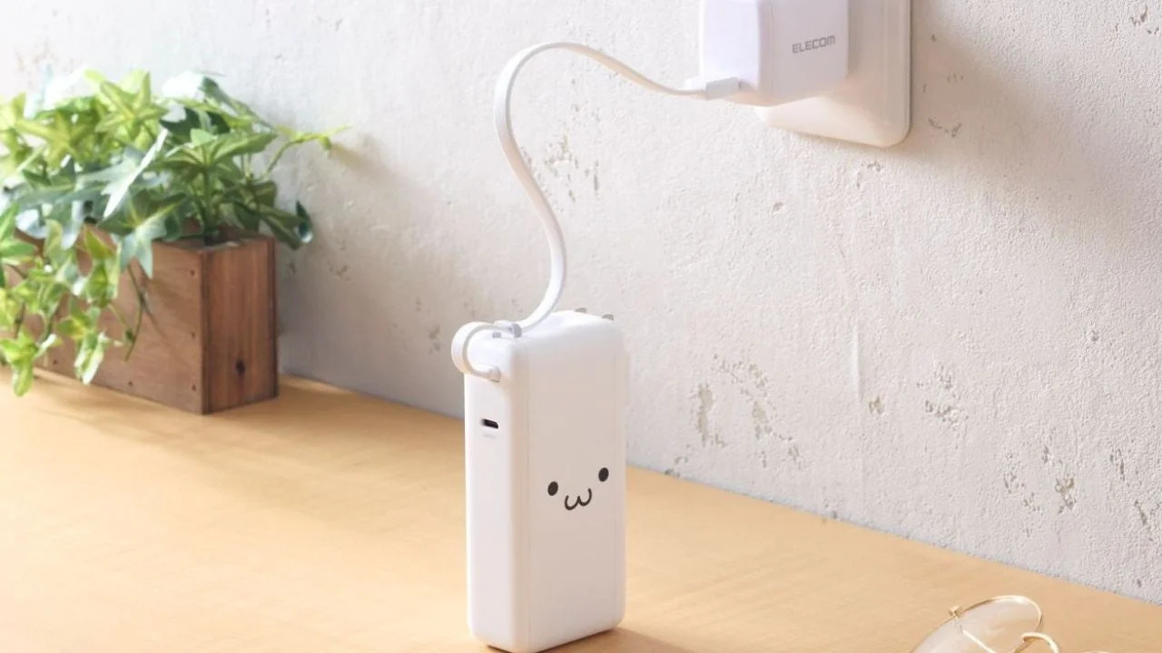ホワイトモデルのエレコム一体型モバイルバッテリーをコンセントに挿して充電する様子
