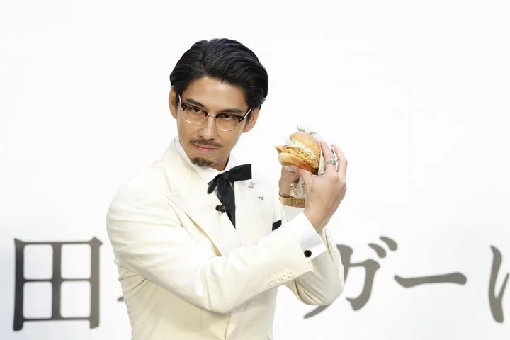 試食後「ケンタの鶏竜田バーガー」を持って感想を語る賀来賢人さん