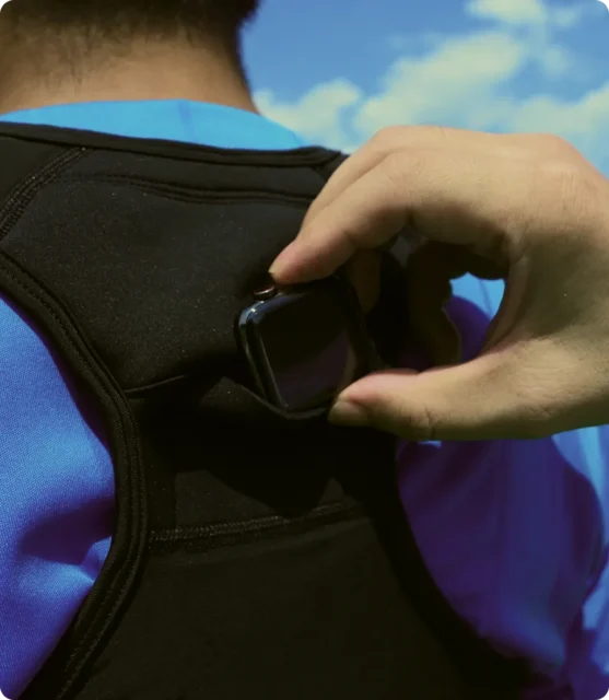 専用スポーツベストの背中ポケットにApple Watchを装着する様子