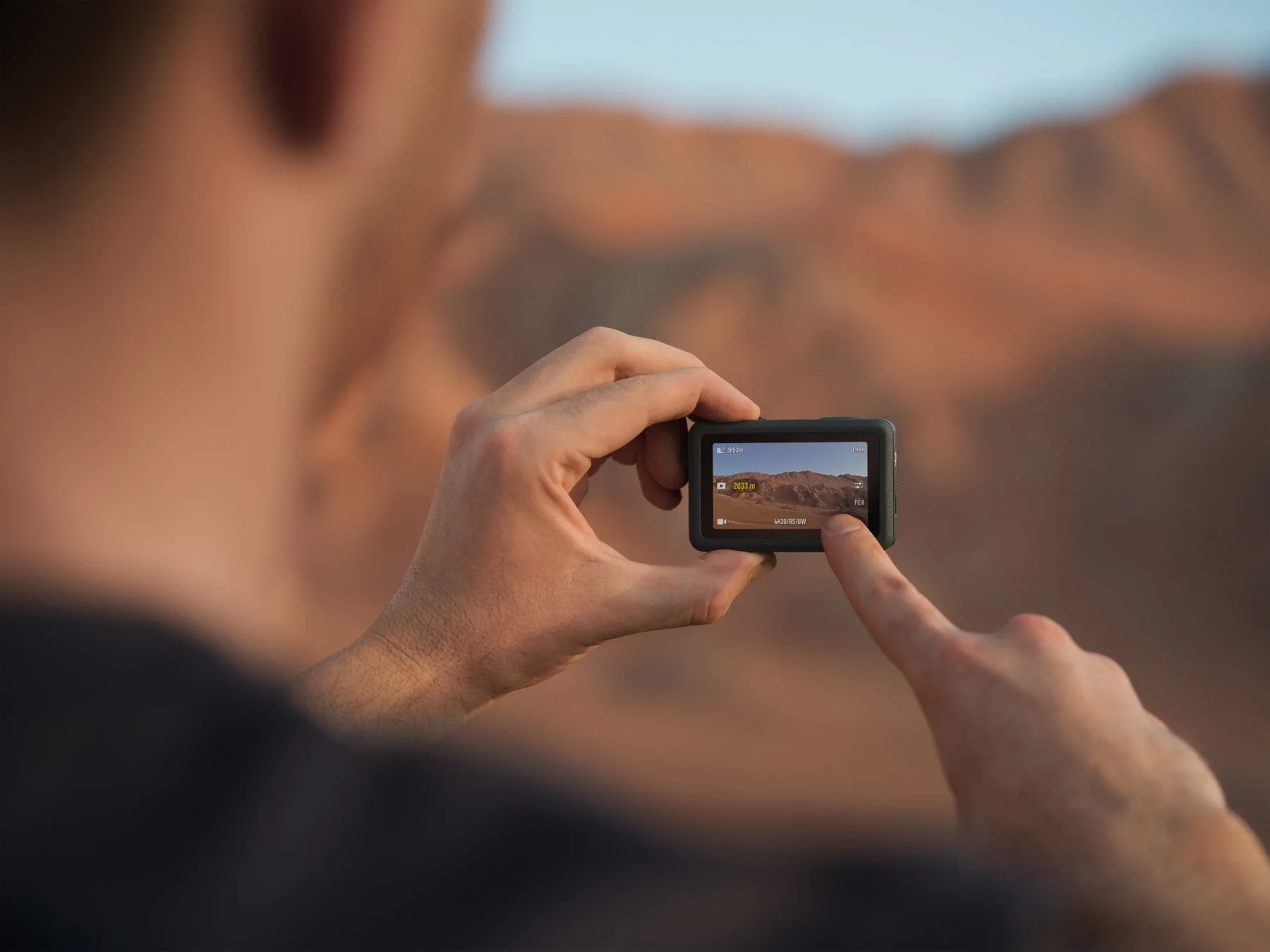 Osmo Action 6のタッチスクリーンを操作し撮影設定を確認する様子