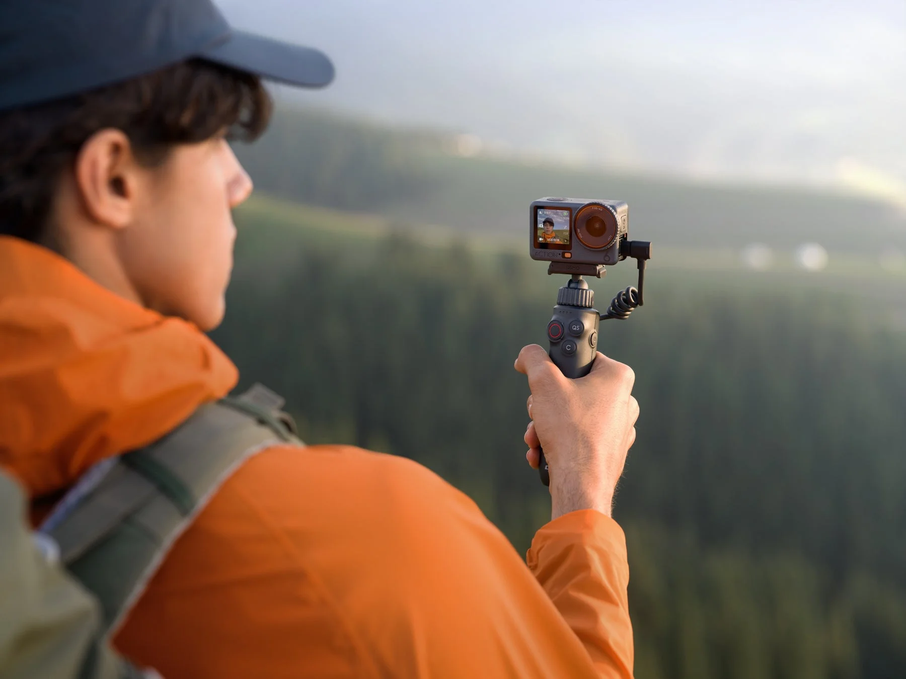 自撮り棒にOsmo Action 6を装着しハイキング中に撮影する男性