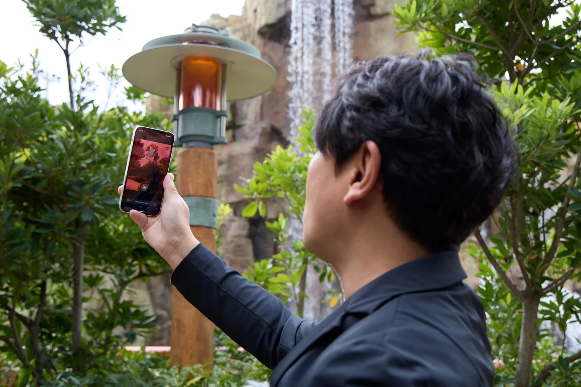 辻本良三さんがスマートフォンでARスタンプラリーを体験する様子