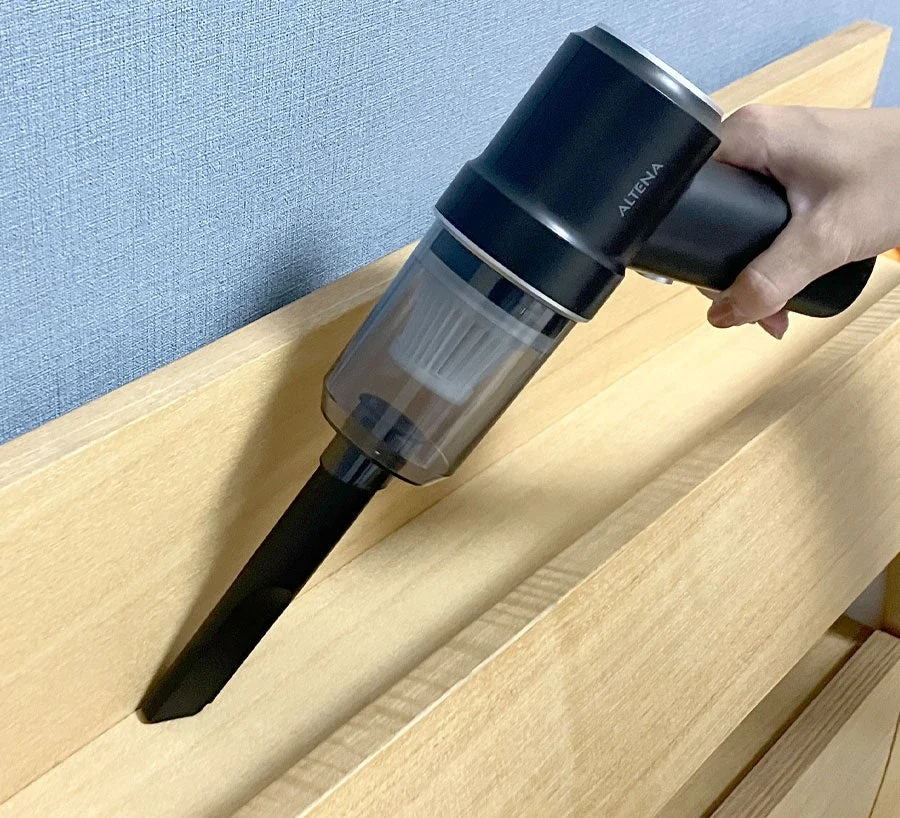 ALTENAハンディクリーナーでベッドの隙間を掃除する様子