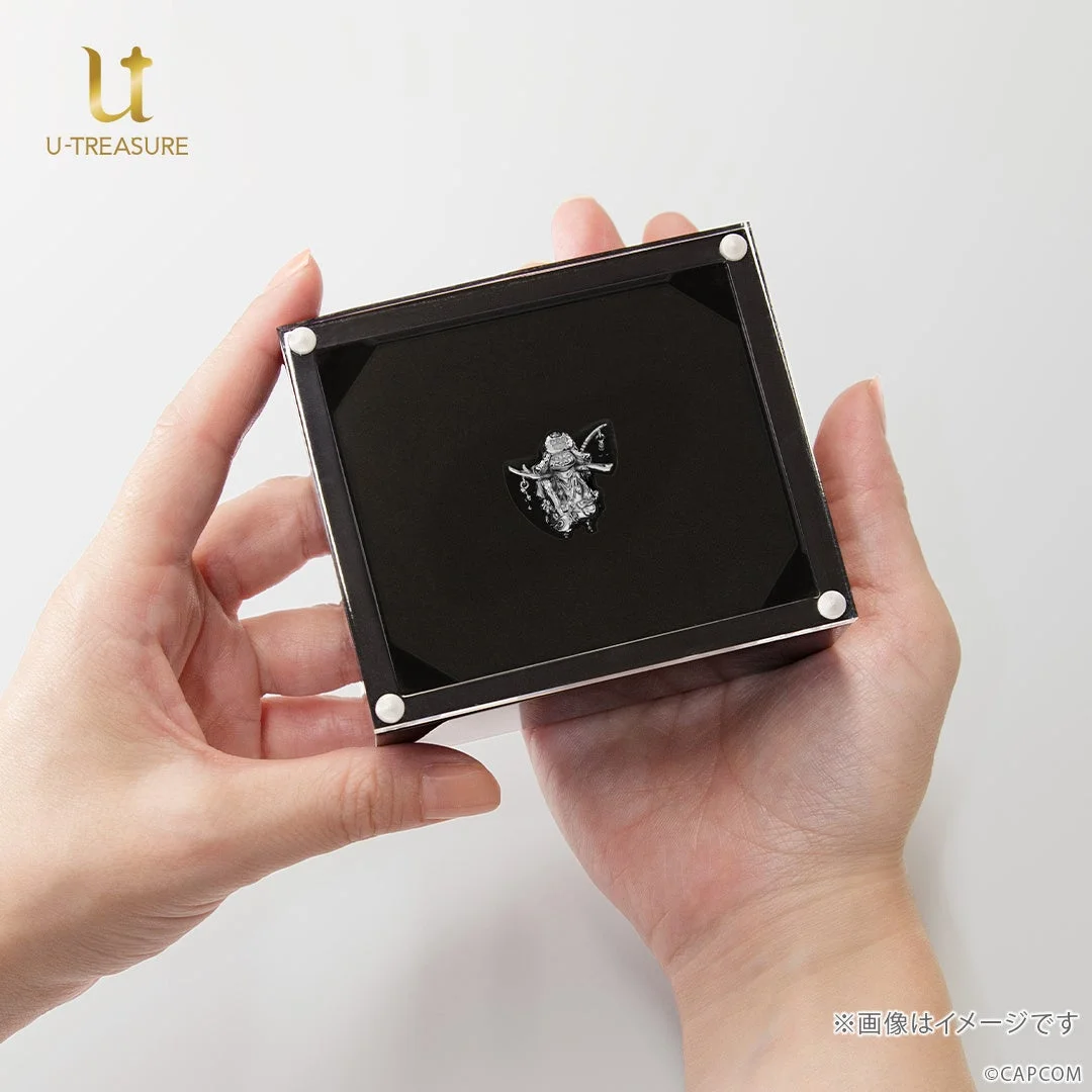 ディスプレイケースに入ったオトモアイルー ミニフィギュアを持つ手