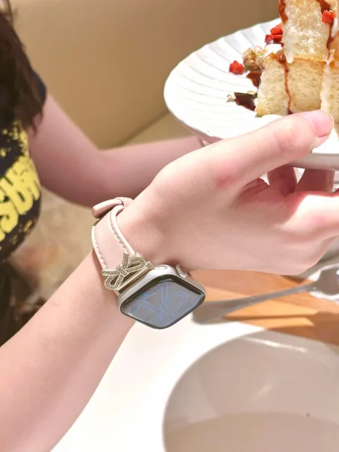 リボンデザインのApple Watchバンドを着用した手元