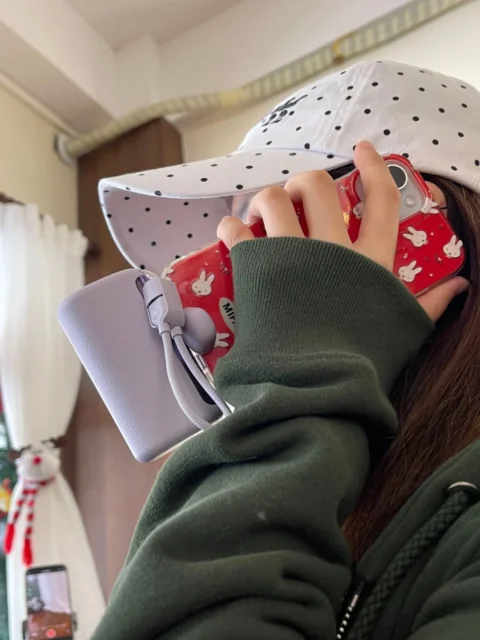 RORRY D2シリーズのパープルのモバイルバッテリーでスマホを充電する手元