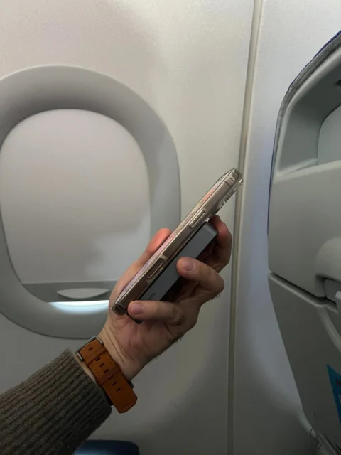 飛行機内でRORRYのリング付きワイヤレス充電器を装着したiPhoneを使用