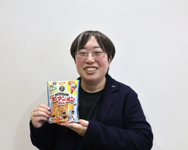 エバラ食品の髙橋美咲さんが「プチッとうどんプラス ニュータンタンメンうどん」を持つ