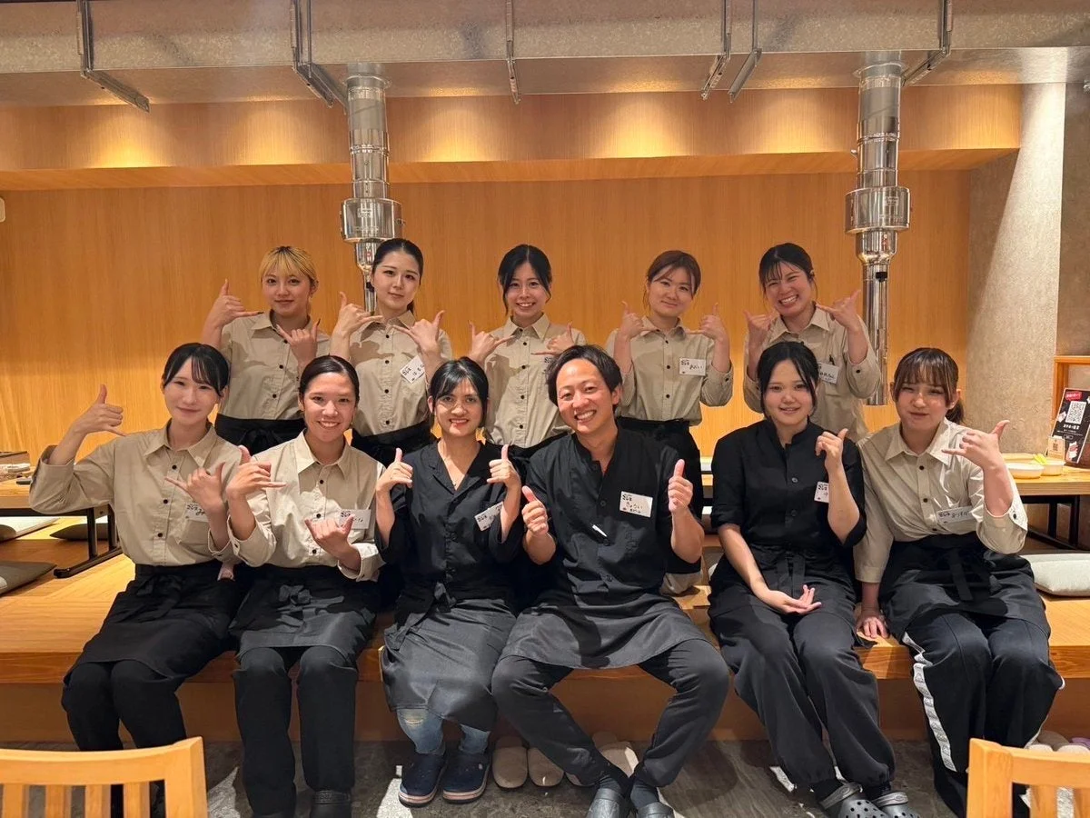 焼肉こじまのスタッフが笑顔でサムズアップする様子