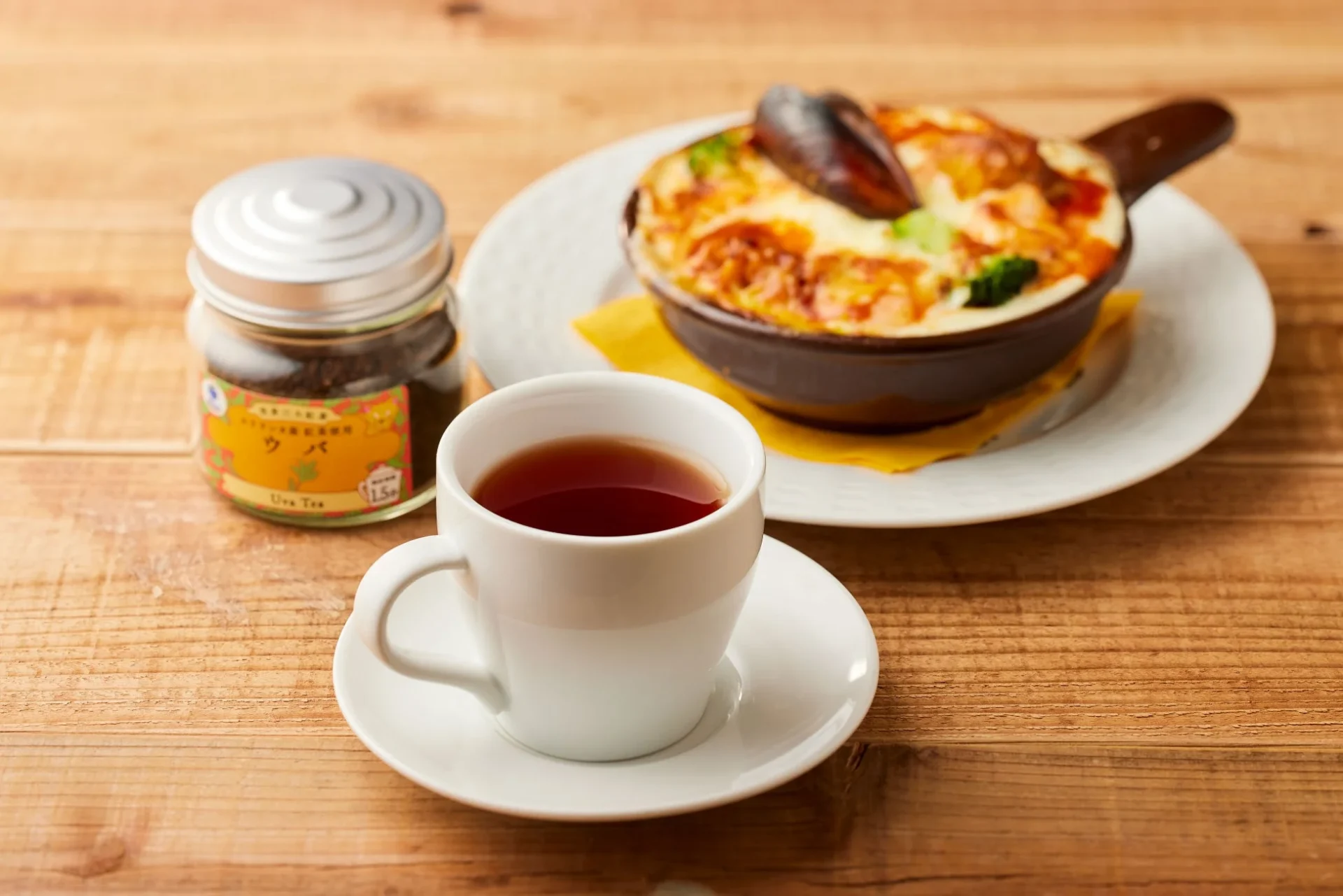 ウバの紅茶と海老とかぼちゃのあふれクリームドリアが木製テーブルに置かれている