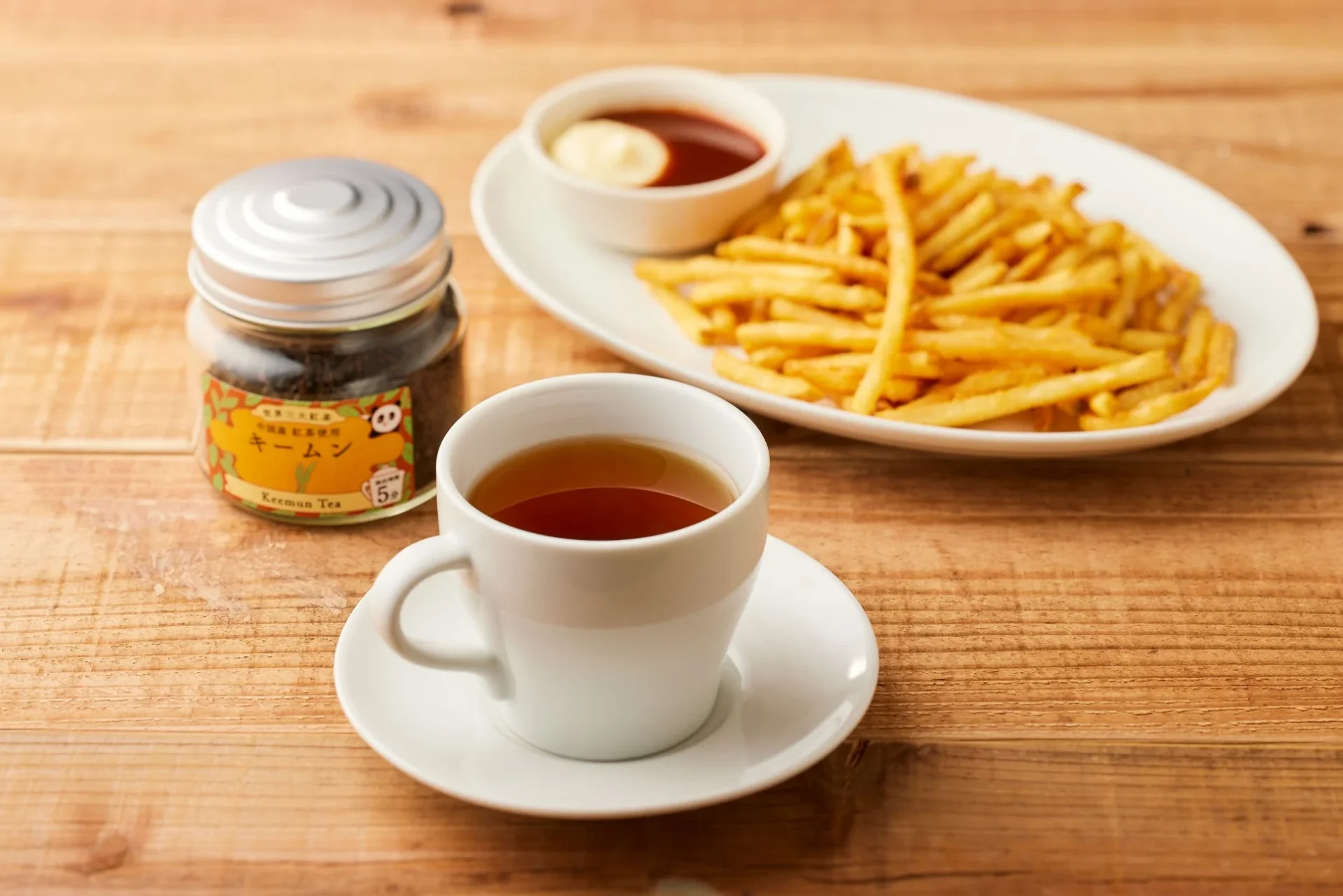 キームンの紅茶とカリカリポテトが木製テーブルに置かれている