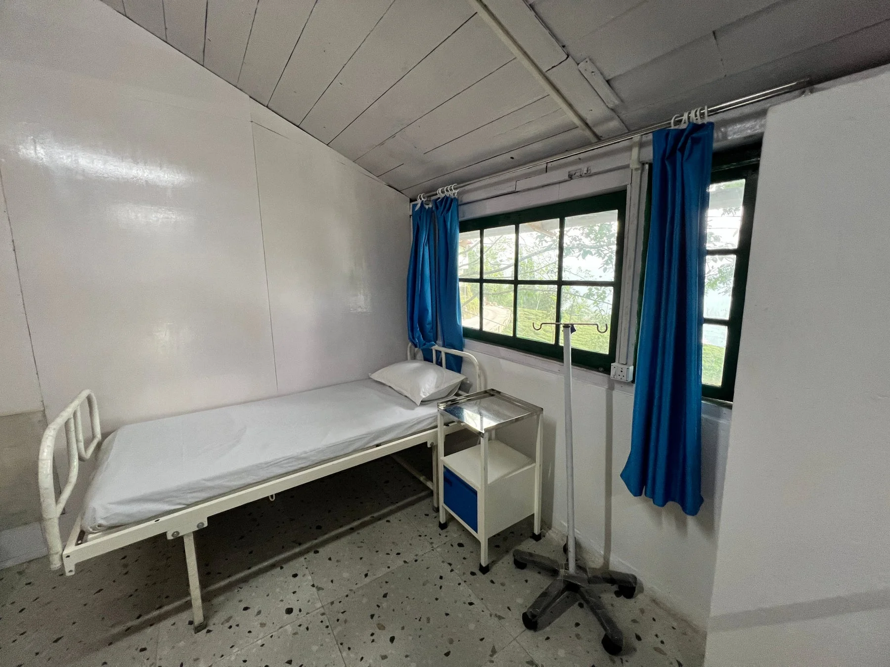 改修されたインドの診療所の内部。ベッドと点滴スタンドが置かれている