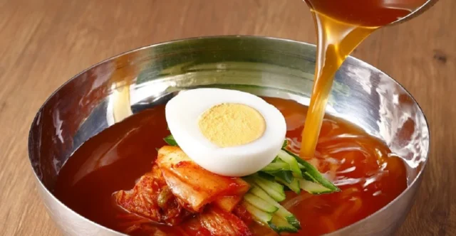 スープが注がれる和民の盛岡冷麺