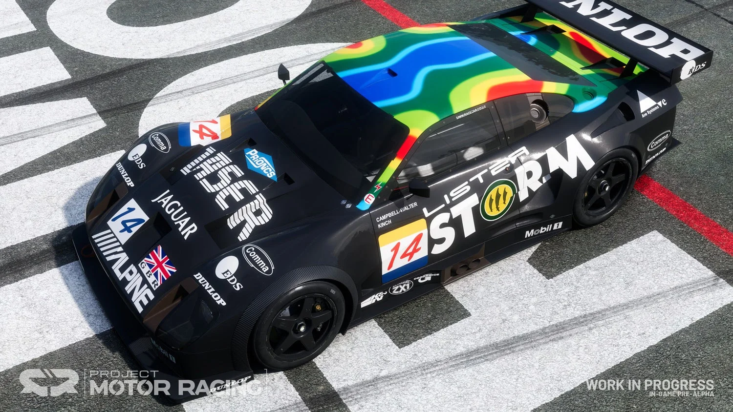 カラフルなグラフィックが施された黒いレーシングカーを上から見た様子。