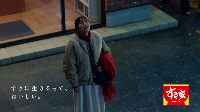 雪が降る中、すき家を見上げて微笑む石原さとみさん