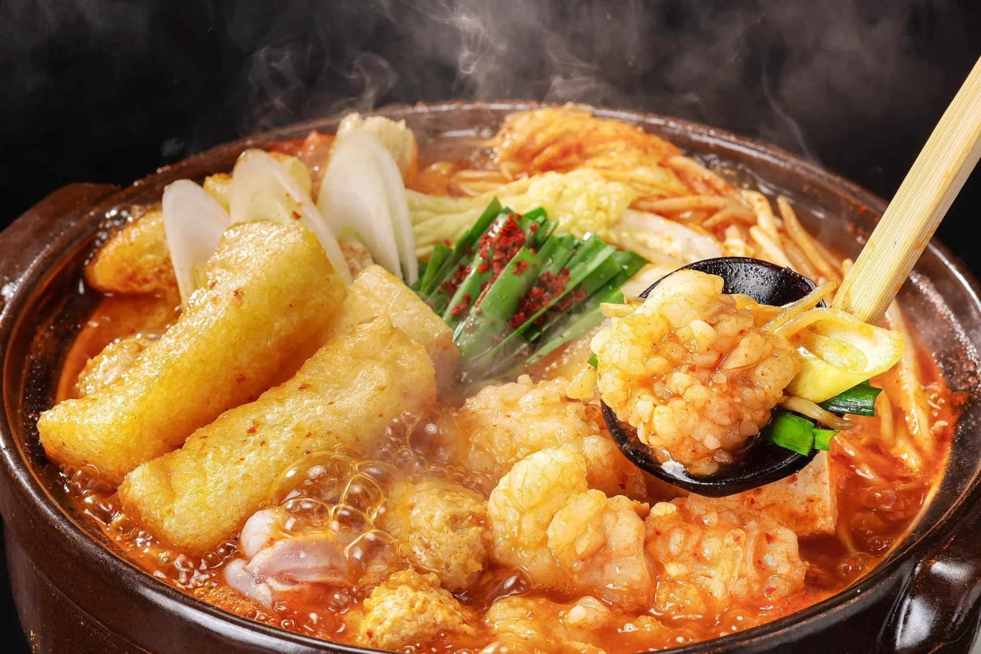 赤から鍋。湯気が立ち上る鍋にモツや野菜がたっぷり入っている。