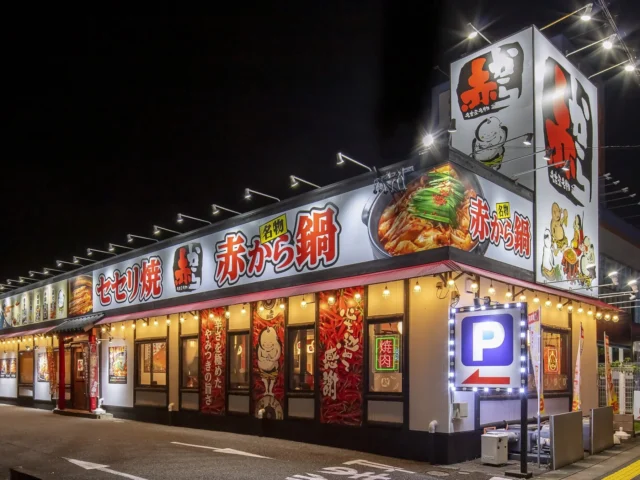 夜間にライトアップされた赤から店舗の外観。看板には「赤から鍋」の文字。