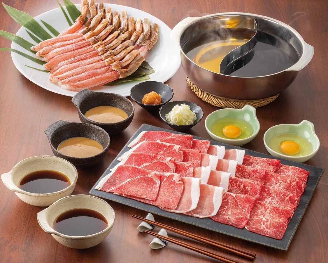 しゃぶ葉の生本ずわい蟹と国産牛、野菜、たれが並んだ豪華なテーブルセット