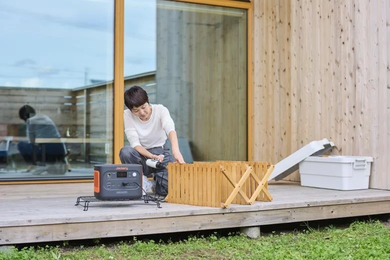 Jackeryポータブル電源を屋外で使用する女性。