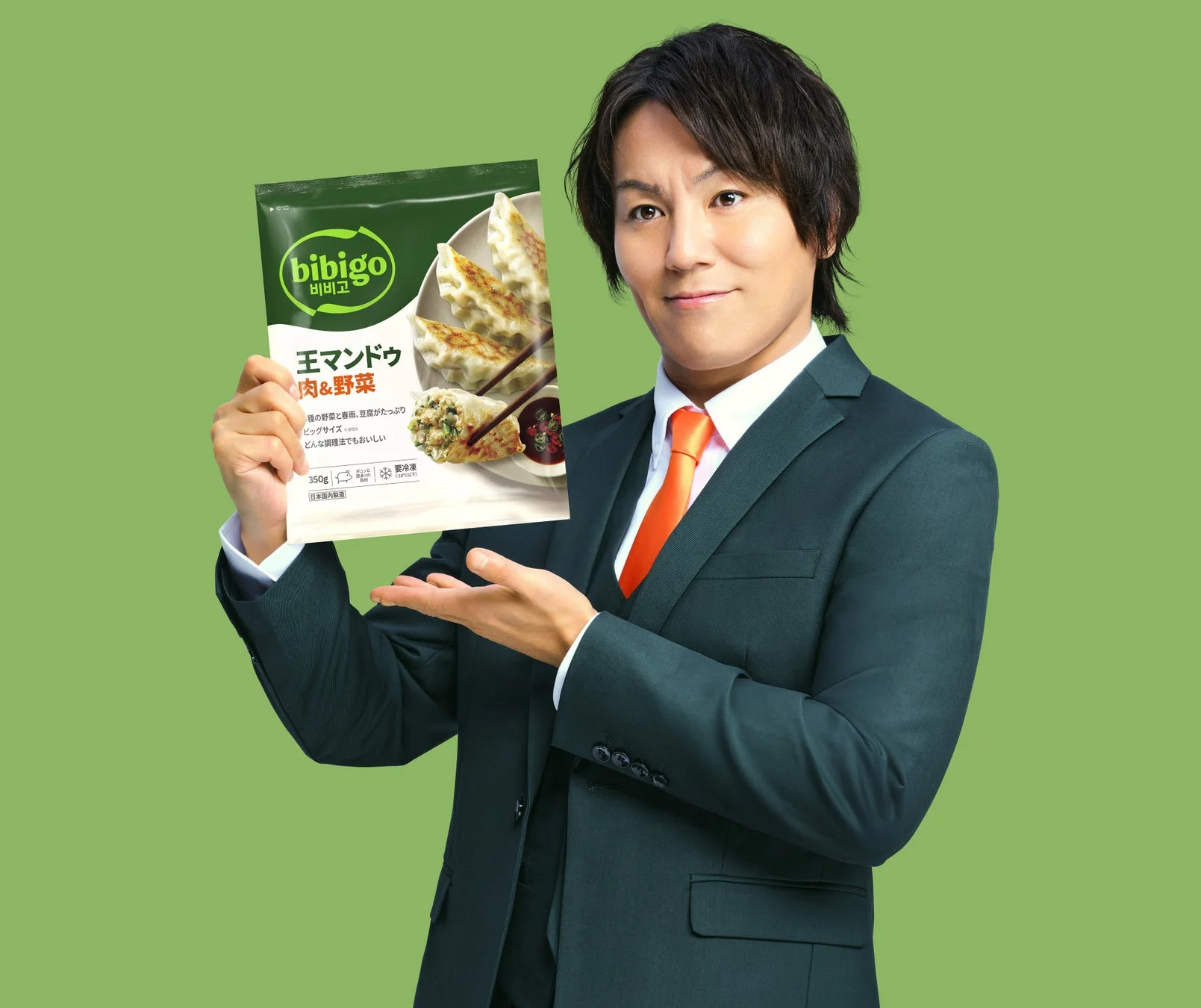 狩野英孝氏が「bibigo王マンドゥ 肉野菜」のパッケージを手に持つ。